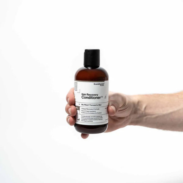 Scandinavian Biolabs Regenerator za oporavak kose Muškarci 250 ml - muškarac drži bočicu proizvoda u ruci.