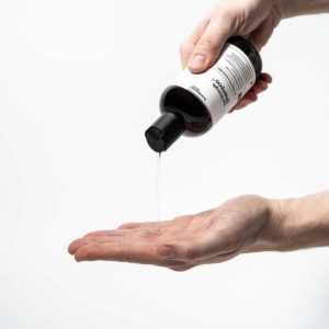 Scandinavian Biolabs Šampon za rast kose Muškarci 250 ml - muškarac izljeva šampon iz bočice na ruku.