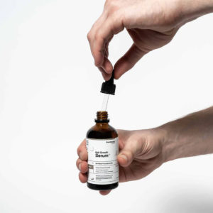 Scandinavian Biolabs Serum za rast kose Muškarci 100 ml - muškarac otvara proizvod i drži pipetu proizvoda u rukama.